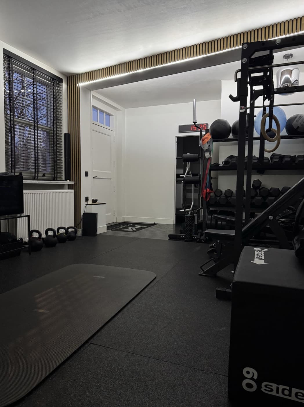 Trainingsruimte met kettlebells, dumbbells en rack